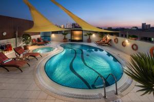 a large swimming pool on top of a building at Savoy Suites Hotel Apartment - Newly Renovated in Dubai