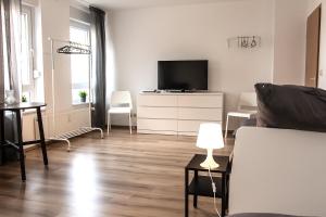 sala de estar con sofá y TV en Spacious 3 Room Apartment with Wifi and Balcony, en Iserlohn