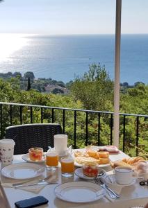 uma mesa com comida com o oceano ao fundo em Hostal Sa Barraca - Adults Only em Begur