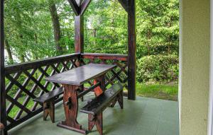 Olsztyn - SiłaにあるBeautiful Home In Gietrzwald With House Sea Viewの木製のテーブルとベンチ付きのポーチ