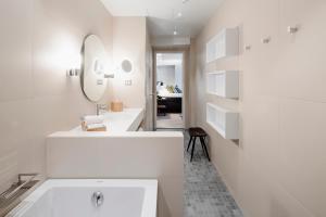 La salle de bains blanche est pourvue d'un lavabo et d'un miroir. dans l'établissement Hotel Indigo Helsinki-Boulevard, an IHG Hotel, à Helsinki