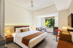 a hotel room with a bed and a television at Lazy Lagoon, Baga A Lemon Tree Resort, Goa in Baga