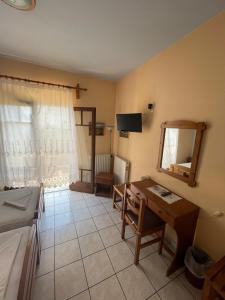 a room with a bed and a desk and a mirror at Villa Sunray in Agios Ioannis Pelio