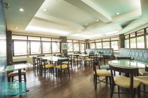 une salle à manger avec tables, chaises et fenêtres dans l'établissement Estancia Resort Hotel, à Tagaytay