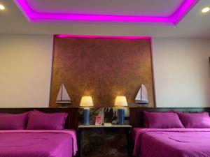a room with two beds with purple lighting at Smile Home Krabi Klong Moung Beach in Klong Muang Beach