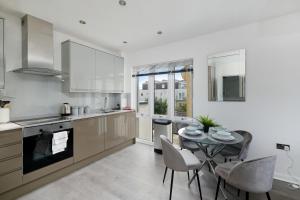 a kitchen and dining room with a table and chairs at Town Center 2 bed Serviced Apartment 08 with parking, Surbiton By 360Stays in Surbiton