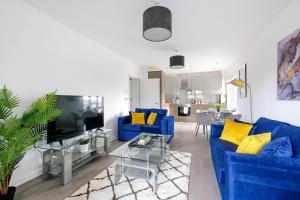un soggiorno con divano blu e cuscini gialli di Town Center 2 bed Serviced Apartment 08 with parking, Surbiton By 360Stays a Surbiton