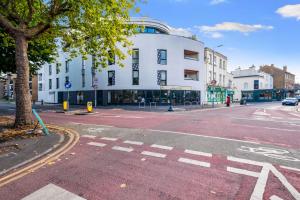 an empty street in front of a white building at Town Center 2 bed Serviced Apartment 08 with parking, Surbiton By 360Stays in Surbiton