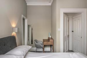 a bedroom with a bed and a desk and a chair at Rock Pool Reach - central location with parking in Broadstairs