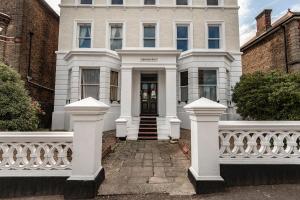 a white house with a white fence in front of it at Rock Pool Reach - central location with parking in Broadstairs