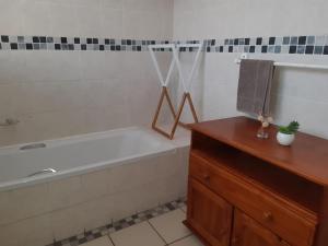 ein Badezimmer mit einer Badewanne und einer Holzkommode in der Unterkunft Seabrook 306 in Margate + 8 Fotos