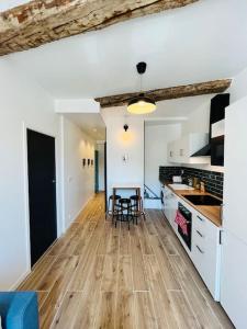 a kitchen with a wooden floor and a table at Superbe appartement au coeur du Mourillon refais à neuf proche des plage in Toulon