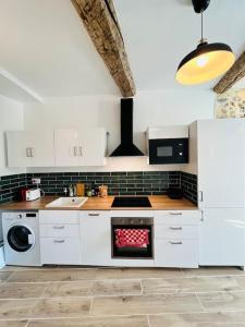 a kitchen with white cabinets and a stove top oven at Superbe appartement au coeur du Mourillon refais à neuf proche des plage in Toulon