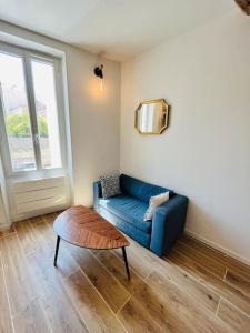 a living room with a blue couch and a coffee table at Superbe appartement au coeur du Mourillon refais à neuf proche des plage in Toulon