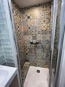 a bathroom with a shower with a tiled wall at Superbe appartement au coeur du Mourillon refais à neuf proche des plage in Toulon