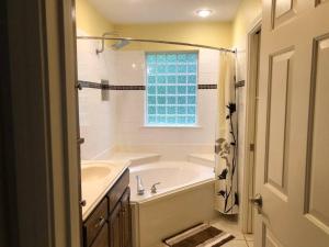 a bathroom with a tub and a sink and a window at Entire lake house at Lake Fork with private bay, boat ramp, fishing light & 8 acres land in Alba +24 photos