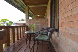 a patio with two chairs and a table on a deck at Collection O 90622 Sehijau Cenang in Pantai Cenang