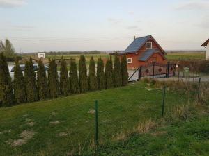 una casa en un campo con una valla en Apartament całoroczny domek grill, 