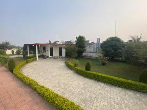 a house with a garden and a brick driveway at Farm Green View Resort in Orchha
