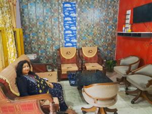 DooN Resort & Farmhouse stay في دهرادون: امرأة تجلس على كرسي في غرفة