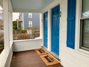 a porch with blue doors and a welcome mat at Bright 2 Br, Pets Welcome, Steps to Lake, Restaurants and Train in Wakefield