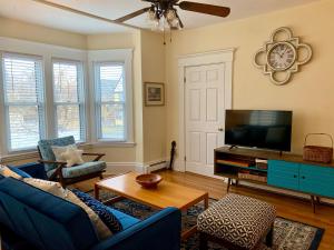 a living room with a blue couch and a tv at Bright 2 Br, Pets Welcome, Steps to Lake, Restaurants and Train in Wakefield
