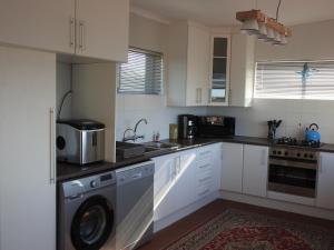 a kitchen with a washing machine and a sink at Boggoms' View in Boggomsbaai