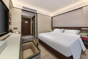 a bedroom with a large white bed and a television at Hotel Fu Shang in Guangzhou