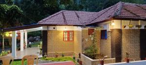 a small brick house with a red window at Munnar Home Stay in Munnar