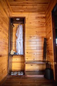 a sauna with a white robe hanging on a wooden wall at Sapa Pine Hill Eco Lodge in Sa Pa