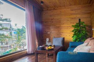 a living room with a blue couch and a table at Sapa Pine Hill Eco Lodge in Sapa