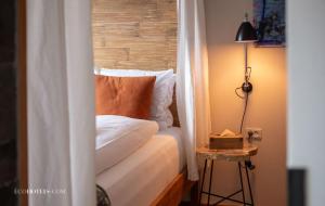 a bedroom with a bed and a table with a lamp at Manon Les Suites Guldsmeden in Copenhagen
