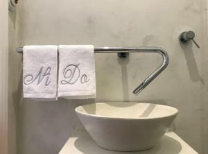 y baño con lavabo blanco y toallas. en Lloēco - Art & Design Guest House, en León