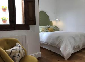 1 dormitorio con 1 cama y 1 silla en Lloēco - Art & Design Guest House, en León