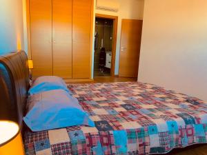 um quarto com uma cama com uma colcha em Apartamento ALTAMIRA T2 SERRA SHOPPING na Covilhã