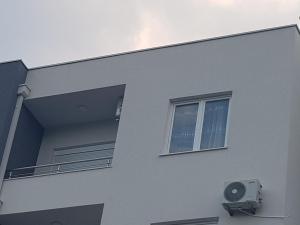 a white building with a window and a air conditioner at Dina & Dona in Ulcinj