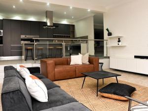 a living room with a couch and a kitchen at Sou House in Louis Trichardt