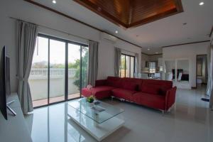 een woonkamer met een rode bank en een glazen tafel bij Private 4 Bedroom Pool Villa NB6 in Hua Hin