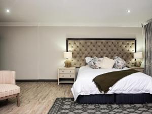 a bedroom with a large bed and a chair at Sou House in Louis Trichardt