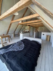 duże łóżko w pokoju z drewnianymi belkami stropowymi w obiekcie Tilia authentic home, butikowe apartamenty nad morzem w mieście Mikoszewo