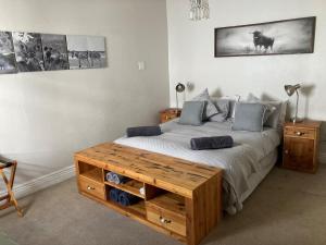 1 dormitorio con 1 cama grande y mesa de madera en Home From Home, Waverley B&B, Johannesburg, en Johannesburgo