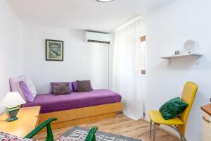 een slaapkamer met een paars bed en een gele stoel bij Apartments with a parking space Buzet, Central Istria - Sredisnja Istra - 17333 in Buzet