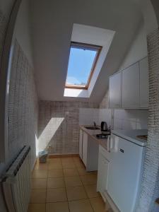 a kitchen with a skylight and white cabinets and a window at Apartments and rooms with WiFi Zagreb - 15959 in Zagreb