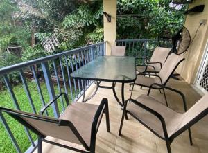 three chairs and a table on a balcony at The Palms 3 bedroom comfort in quiet court in Darwin
