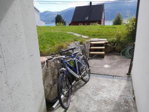 un vélo bleu garé contre un mur à côté d'un bâtiment dans l'établissement Ålesund Apartment with free parking, à Ålesund