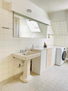 y baño con lavabo y lavadora. en aday - Frederikshavn City Center - Charming double room, en Frederikshavn