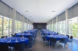 a row of tables and chairs in a room with large windows at K Gallery Hotel in Pasuruan