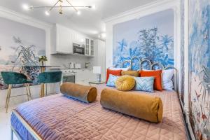 ein Schlafzimmer mit einem großen Bett mit orangefarbenen und blauen Kissen in der Unterkunft L'Eden studio with a balcony - Lake View in Montreux
