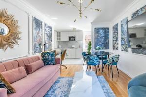 モントルーにあるBon Port 1-bedroom apartment – Lakefrontのリビングルーム(ピンクのソファ、青い椅子付)