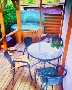 einen Tisch und Stühle auf einer Terrasse mit Pool in der Unterkunft Royal Resident in Druskininkai